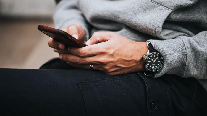 Jemand hält ein Smartphone in der Hand und tippt eine Nachticht